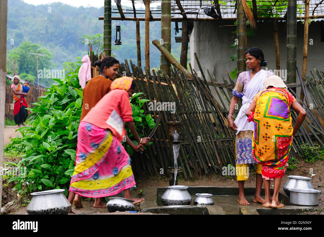Les femmes le pompage de l'eau d'une pompe à main, Jorhat, Assam, Inde, Asie Banque D'Images