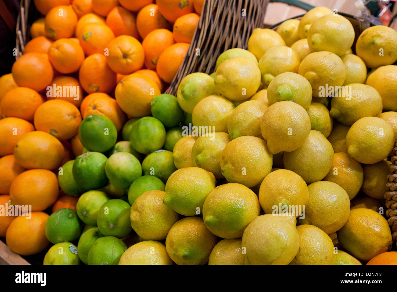 Citrons limes et oranges, Rutaceae, agrumes sur le plateau prêt à la vente sur le marché Banque D'Images