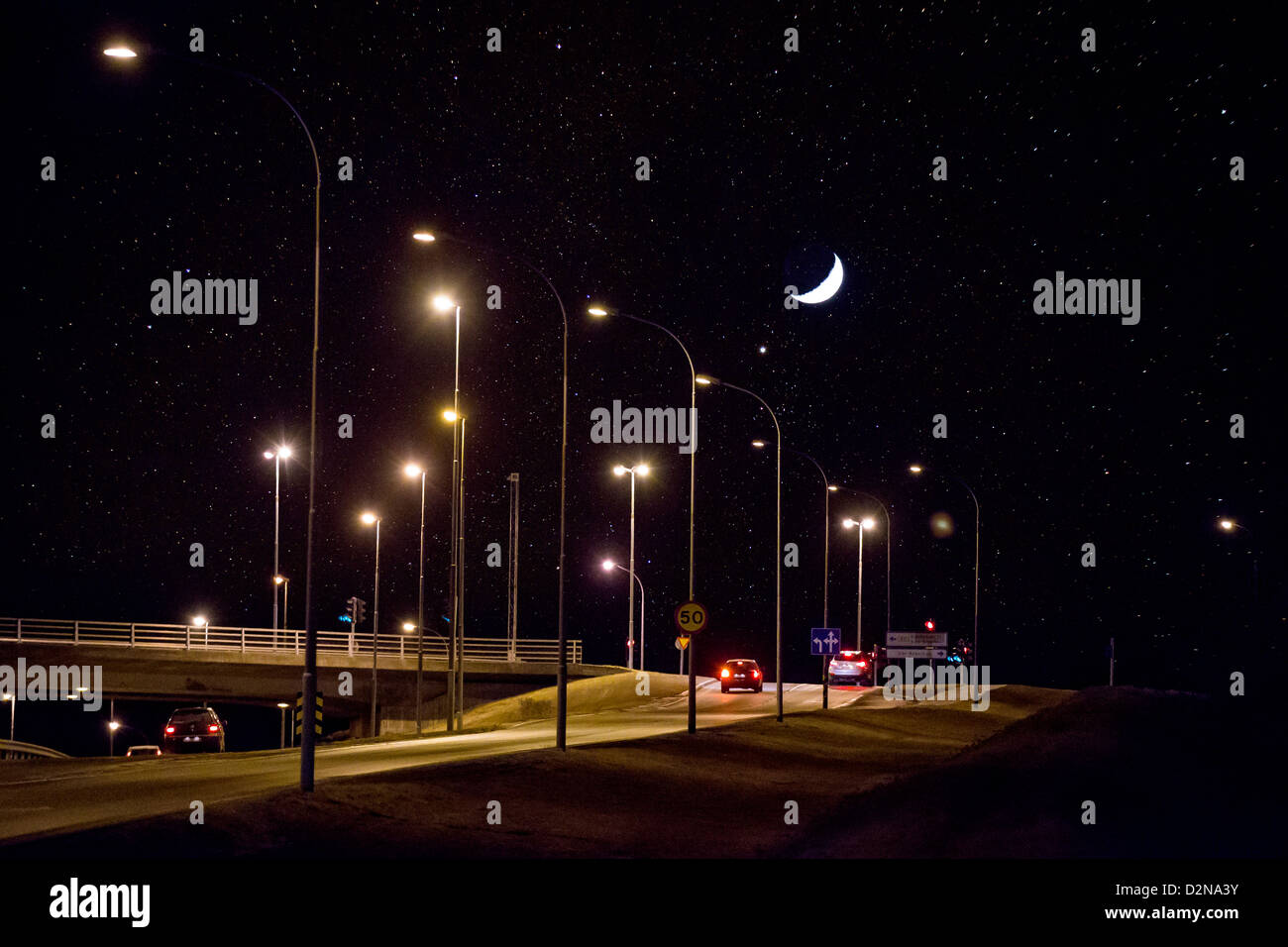 Croissant de lune et de nuit étoilée au-dessus de la route, Reykjavik Islande Banque D'Images