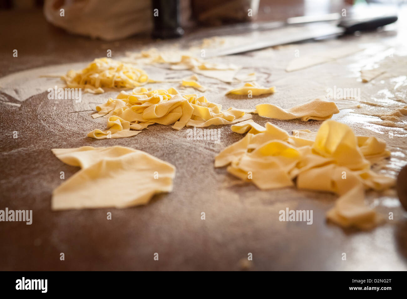 Pâtes fraîches pour lasagne plats laminés à chaud à l'aide d'une aiguille longue pour que les macaronis ou les "petites oreilles" Oriecchetti. Banque D'Images