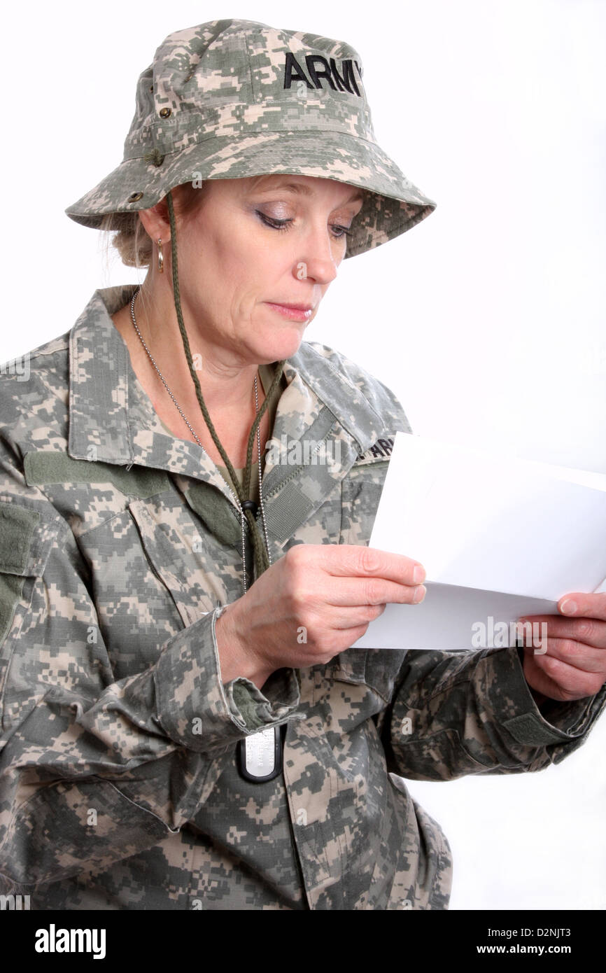 Une femme soldat militaire USA triste de lire une lettre d'accueil Banque D'Images