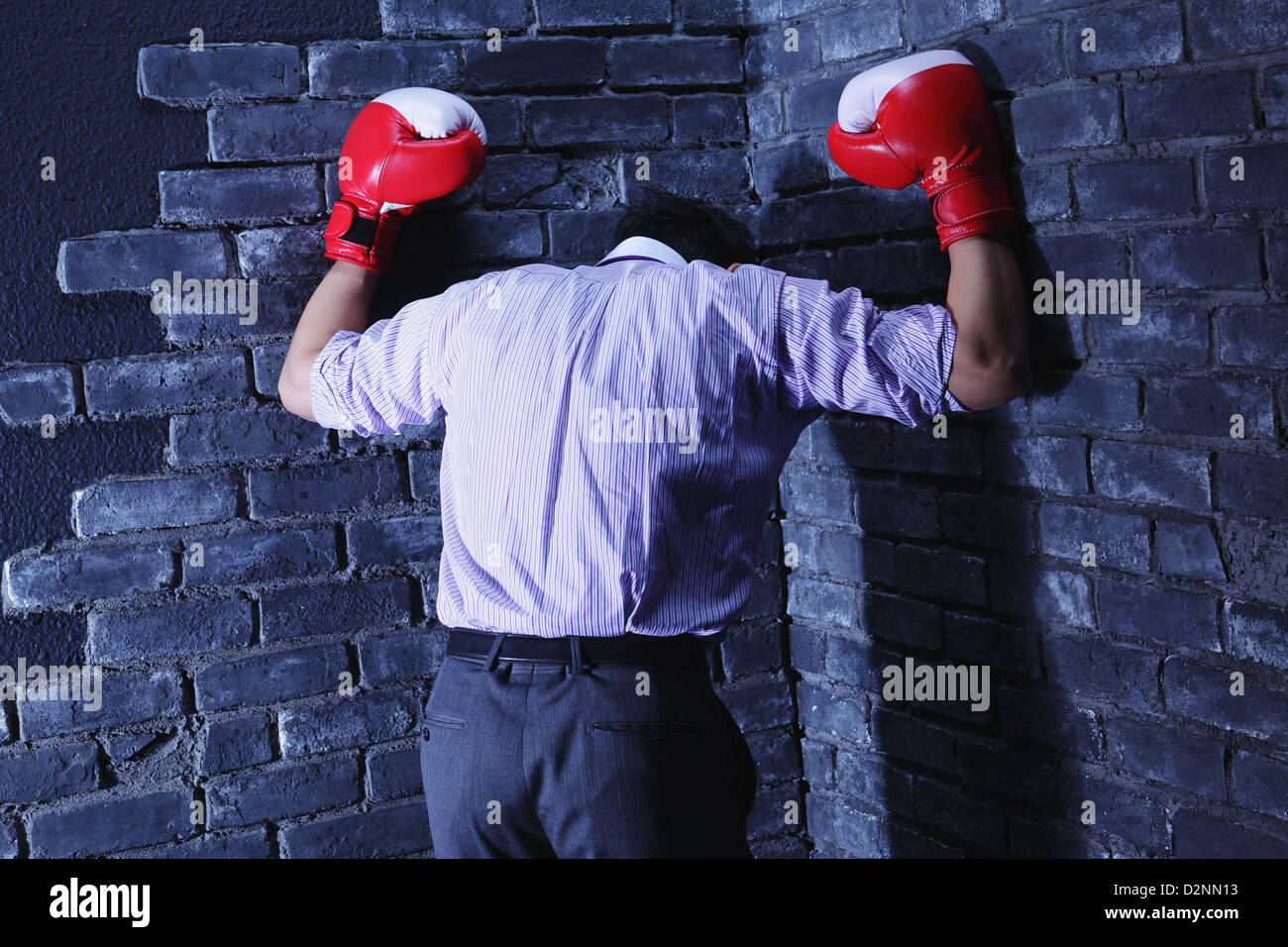 Businessman avec des gants de boxe contre un mur Banque D'Images