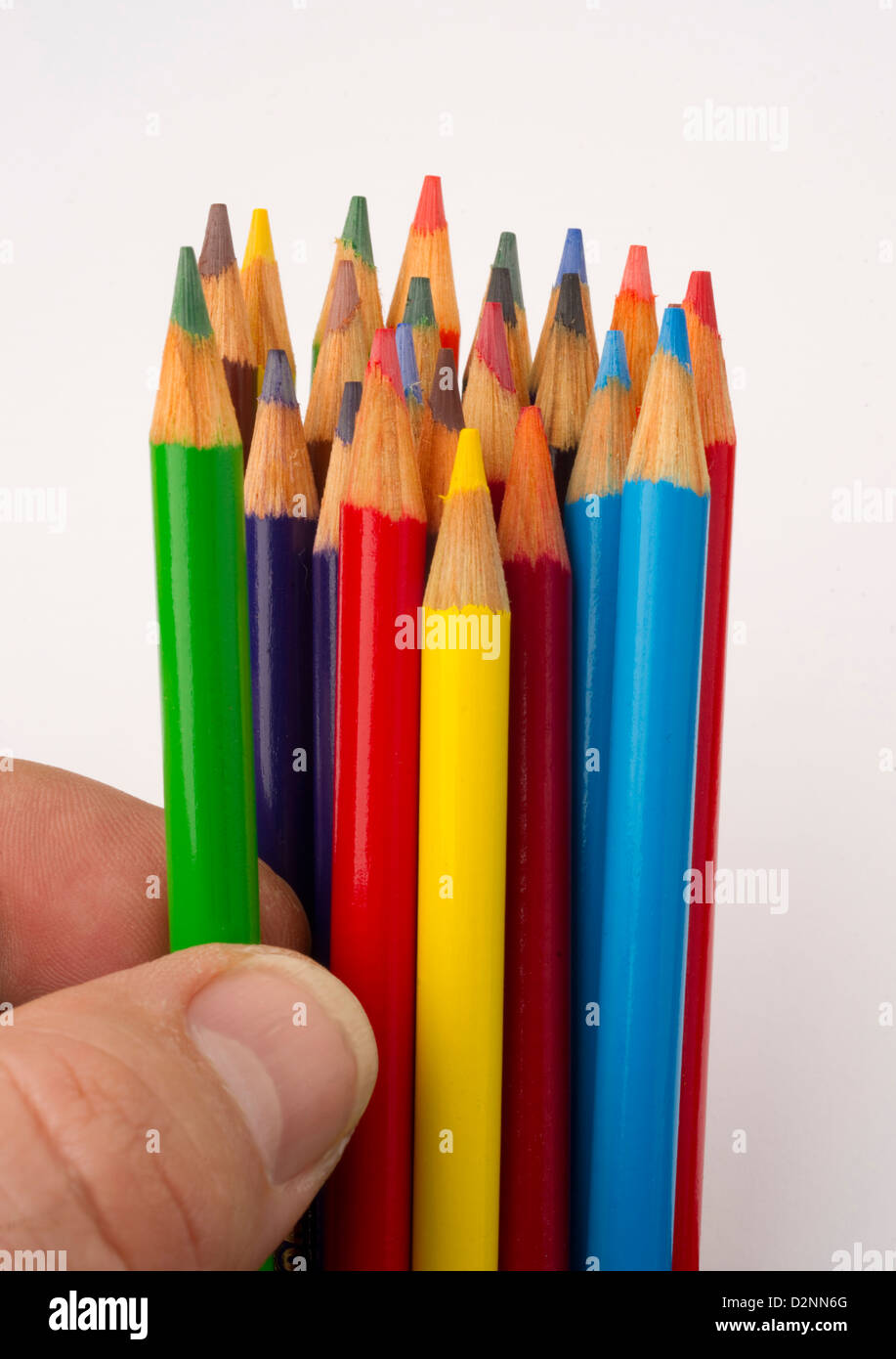Un crayon de couleur verte est choisi à partir d'un groupe de fournitures artistiques Banque D'Images