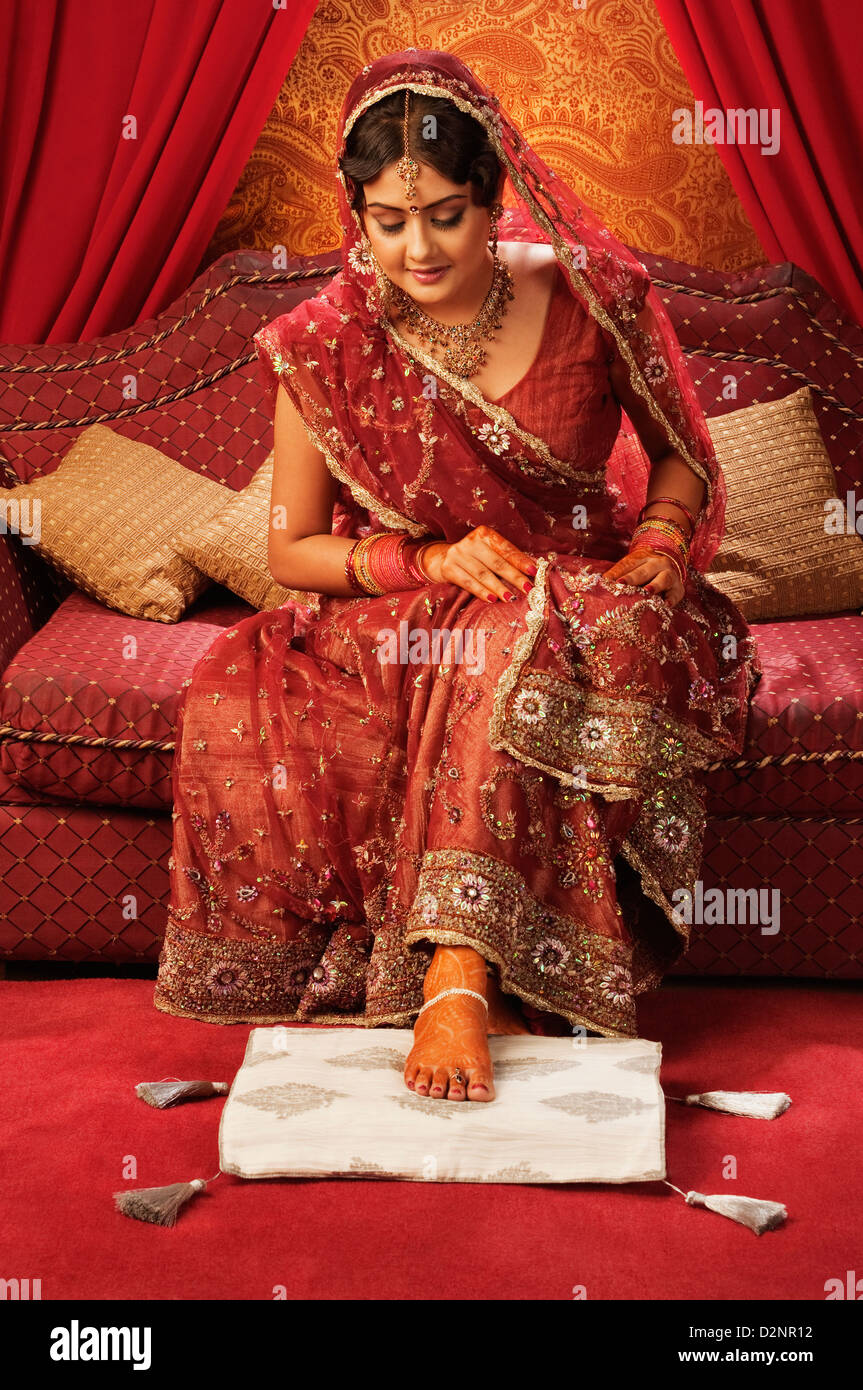 Mariée en robe de mariage traditionnel à la décoration au henné sur son pied Banque D'Images