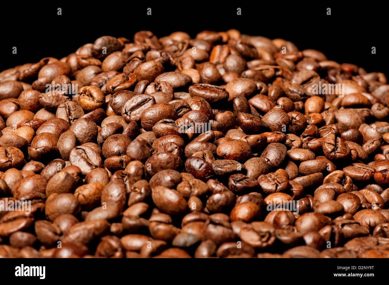 Tas de grains de café sur fond noir Banque D'Images
