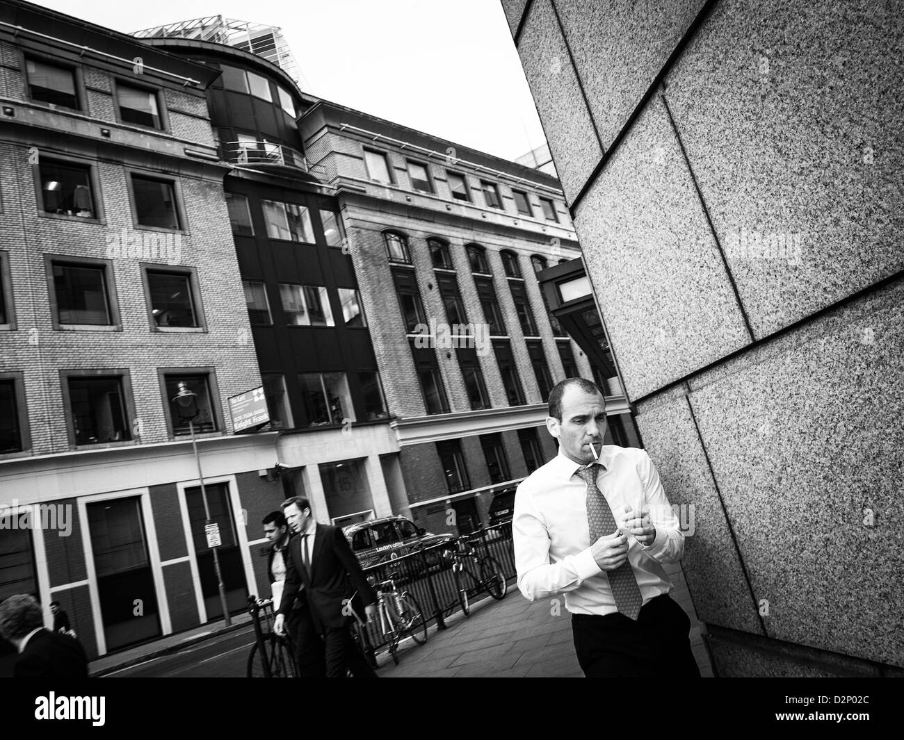 Un homme en chemise blanche va fumer dans un matin dans la ville, Londres Banque D'Images