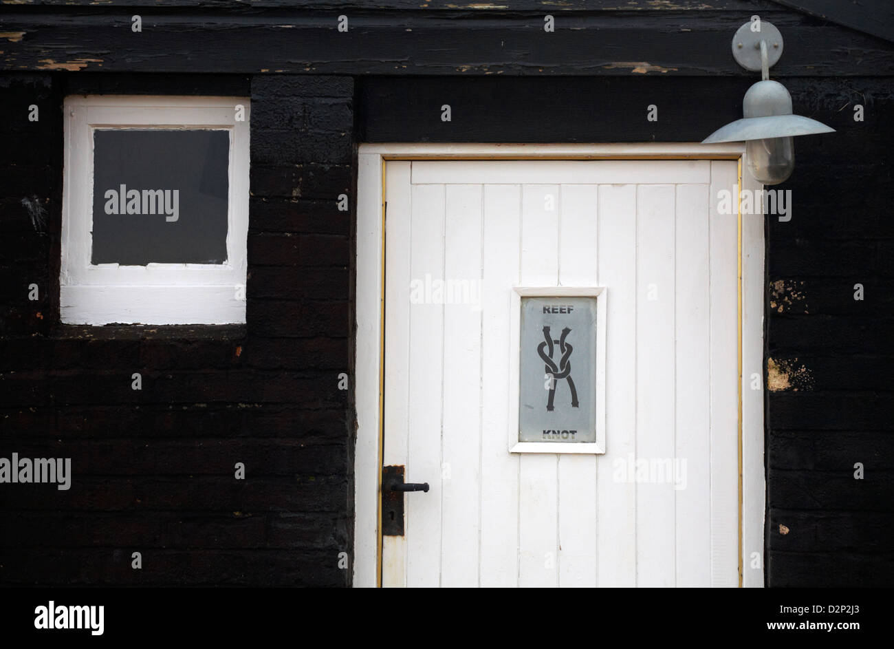 Enseigne Reef Knot sur porte blanche avec lampe et fenêtre sur Coastguard Cottage à Mudeford Hengistbury Head, Christchurch, Dorset en janvier hiver Banque D'Images