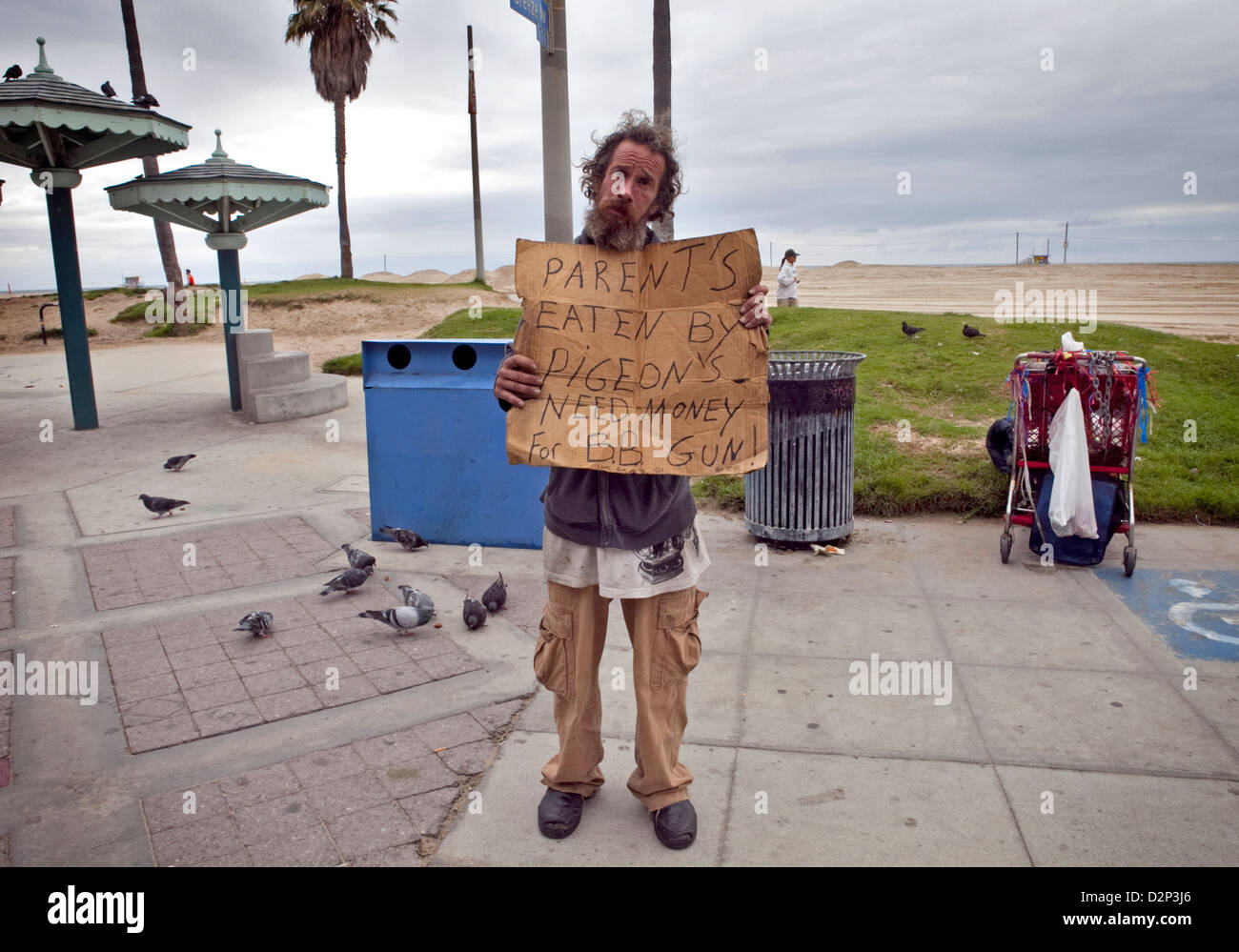 Les sans-abri guy sur Venice Beach Ocean Front Walk avec drôle signe, 2010 Banque D'Images