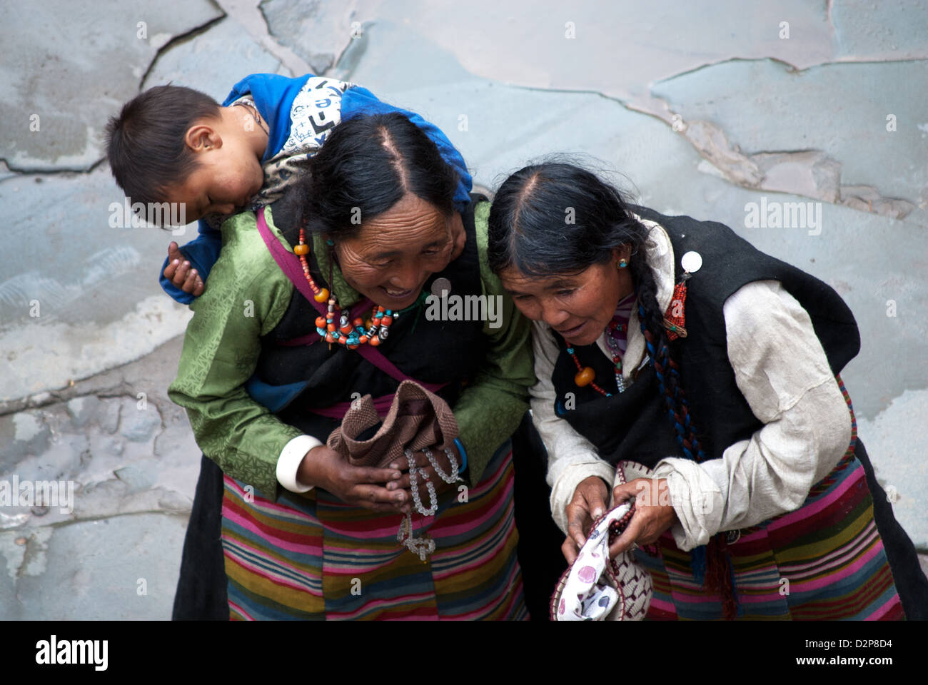Les femmes tibétaines en costume traditionnel de rire, enfant endormi sur le dos, Lhassa, Tibet, Chine Banque D'Images