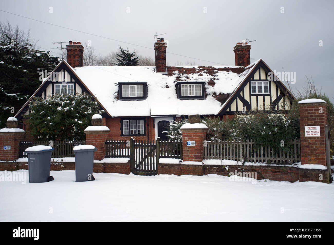 Maisons dans la neige avec les wheelie bins Banque D'Images