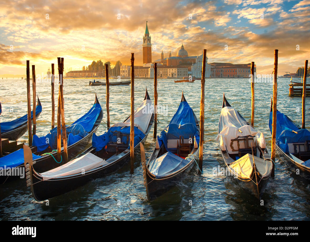 Gondoles à la place St Marc avec l'île de San Giorgio Maggiore derrière , au coucher du soleil Venise Italie Banque D'Images