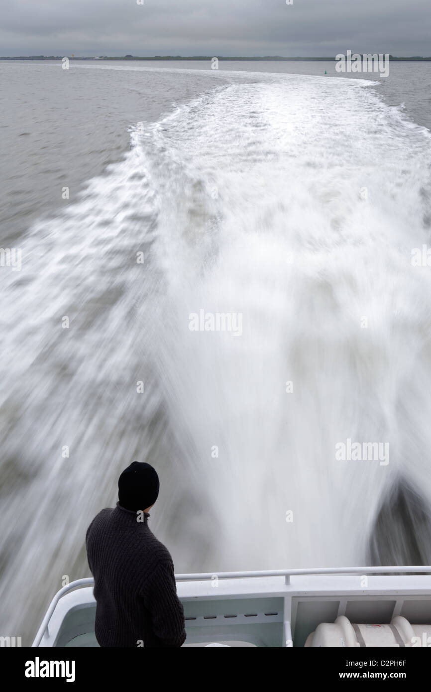 Plage du Nord, l'Allemagne, un homme à l'arrière d'un bateau Banque D'Images