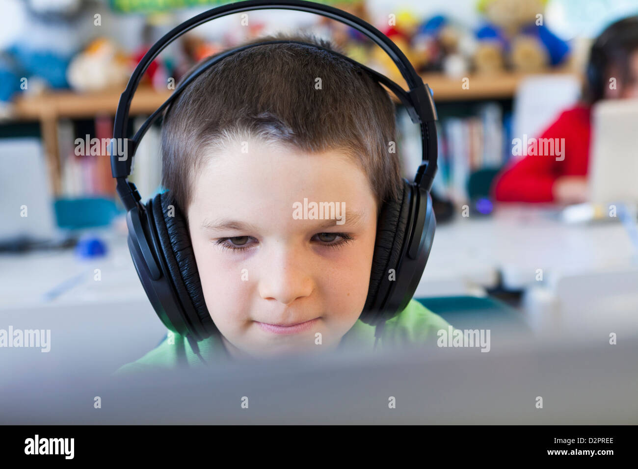Caucasian student in headphones using laptop in classroom Banque D'Images