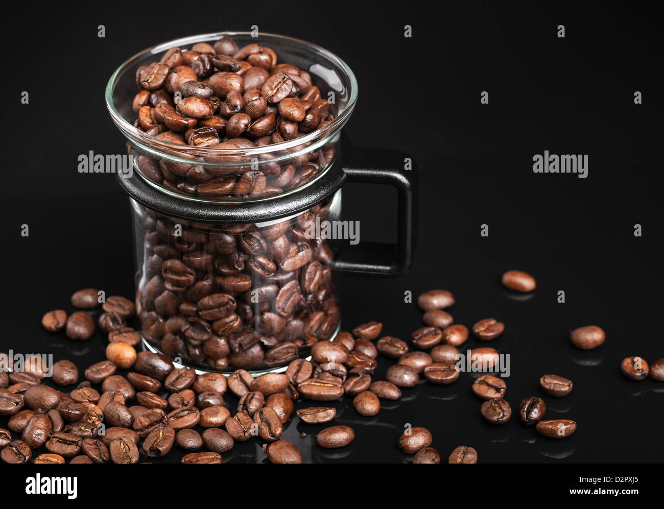 Mug avec ensemble de grains de café torréfiés sur noir Banque D'Images