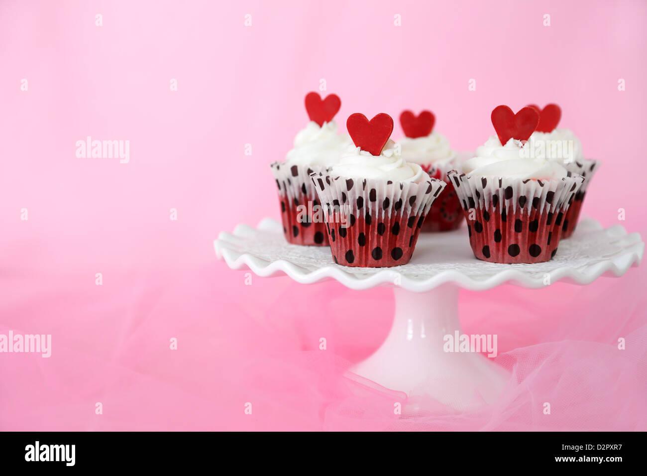 Red Velvet cupcakes avec glaçage au fromage à la crème au chocolat rouge décoré de coeurs. Copie de l'espace sur le côté. Banque D'Images