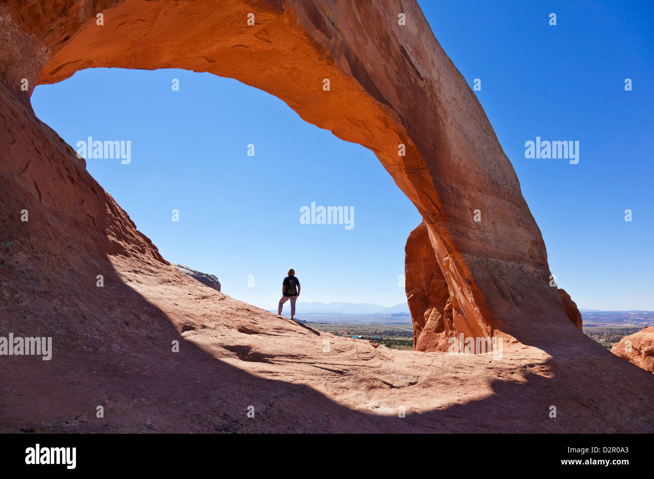 Tourisme au randonneur solitaire Wilson Arch, près de Moab, Utah, États-Unis d'Amérique, Amérique du Nord Banque D'Images