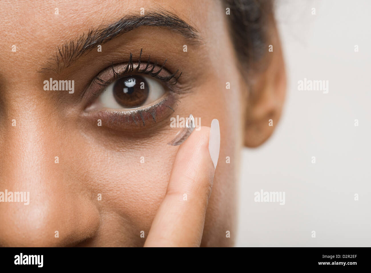 Woman putting on contact lens Banque D'Images