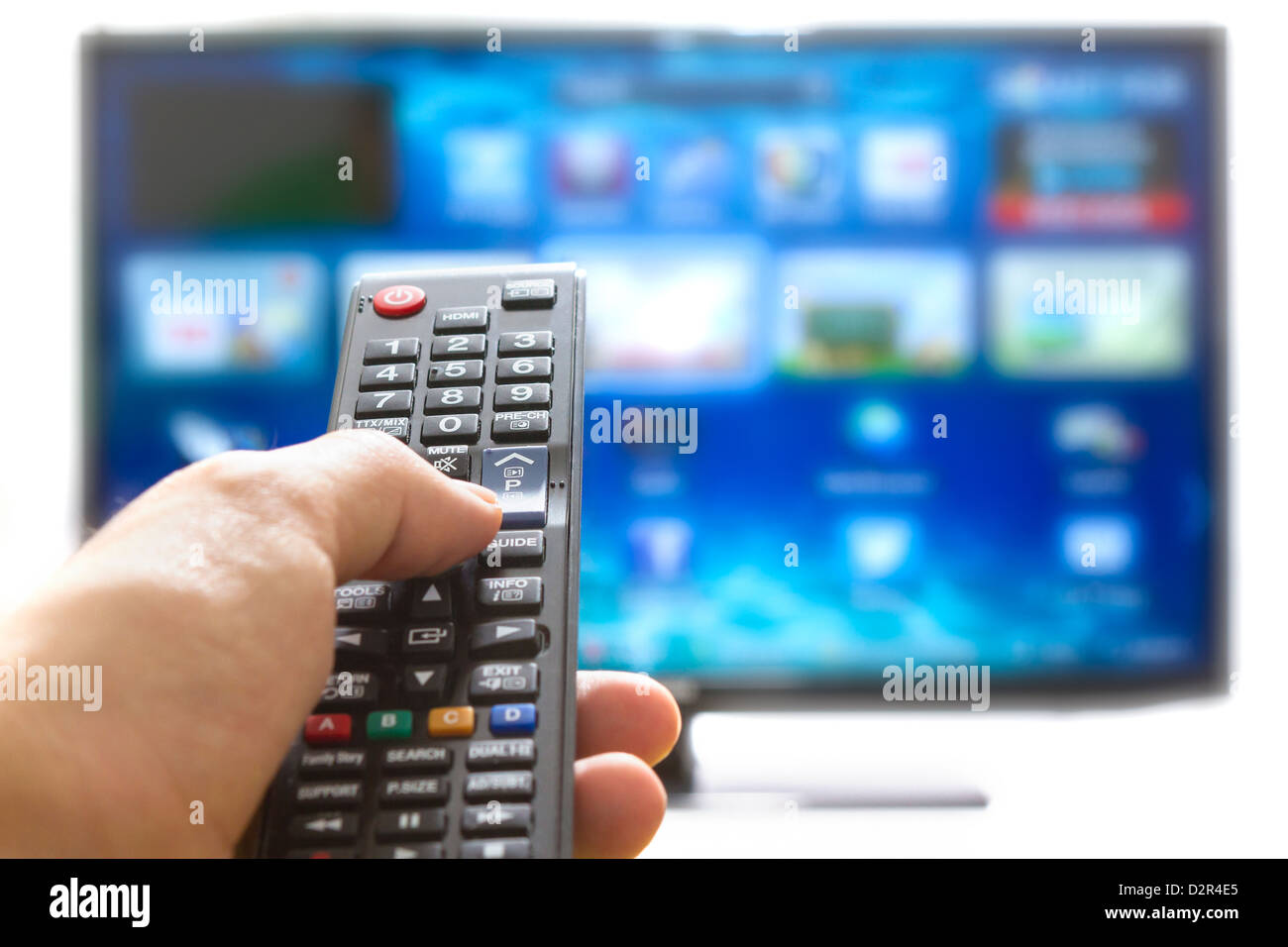 Télécommande de télévision change de chaîne pouce sur l'écran plat bleu Banque D'Images