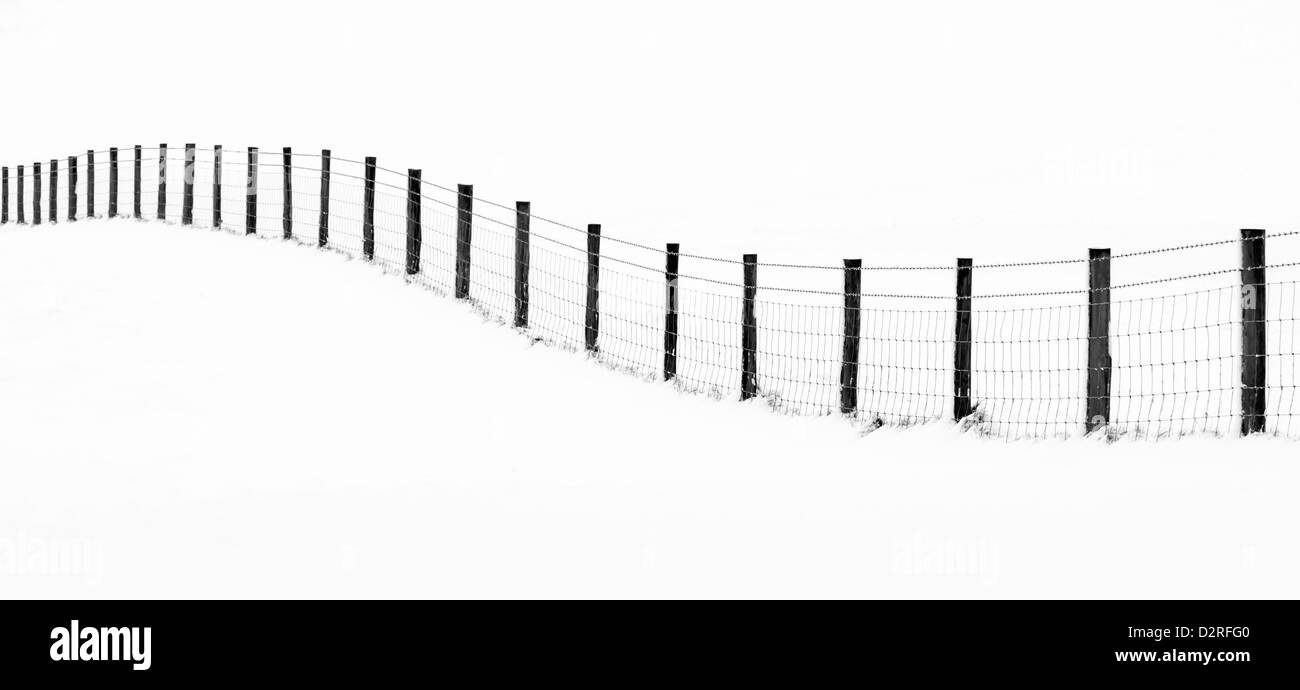 Une clôture en ondulant d'un paysage enneigé Banque D'Images