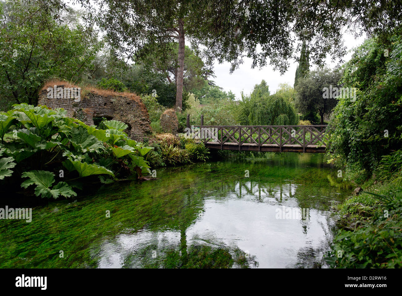 Le pont de bois appelé Ponte di Legno traversant la rivière. Jardin de Ninfa. Le Latium. Italie Banque D'Images