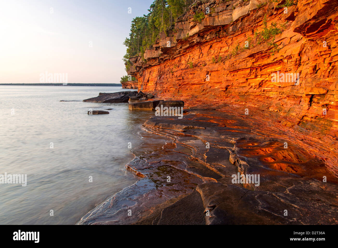 Falaises de grès stratifiés et les grottes de la mer au lever du soleil sur l'île de diables dans des îles Apostle National Lakeshore, Wisconsin, États-Unis Banque D'Images