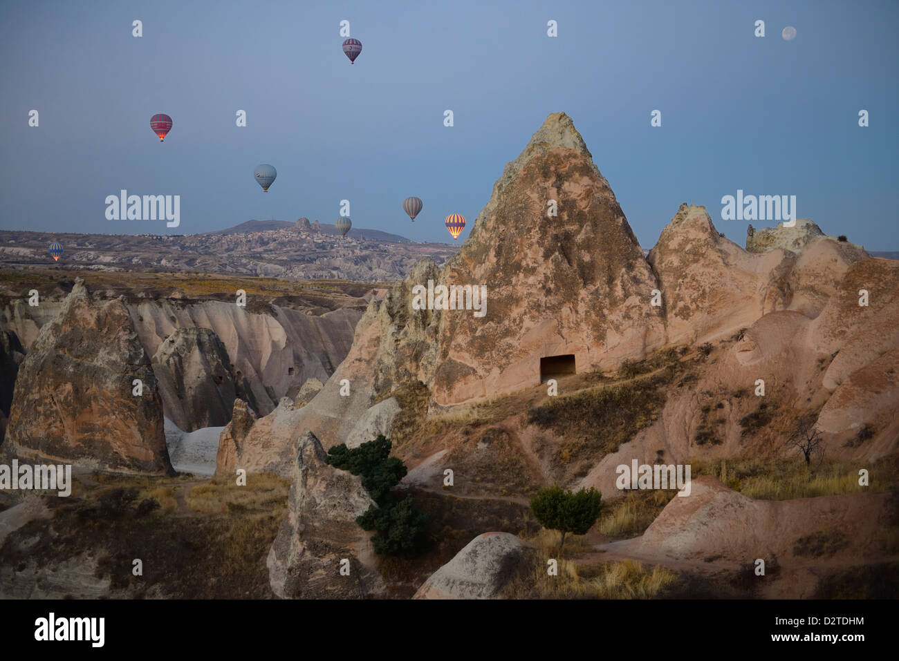 Vue de la ville d'Uchisar Cappadoce en Turquie avant l'aube avec lune d'un ballon à air chaud Banque D'Images