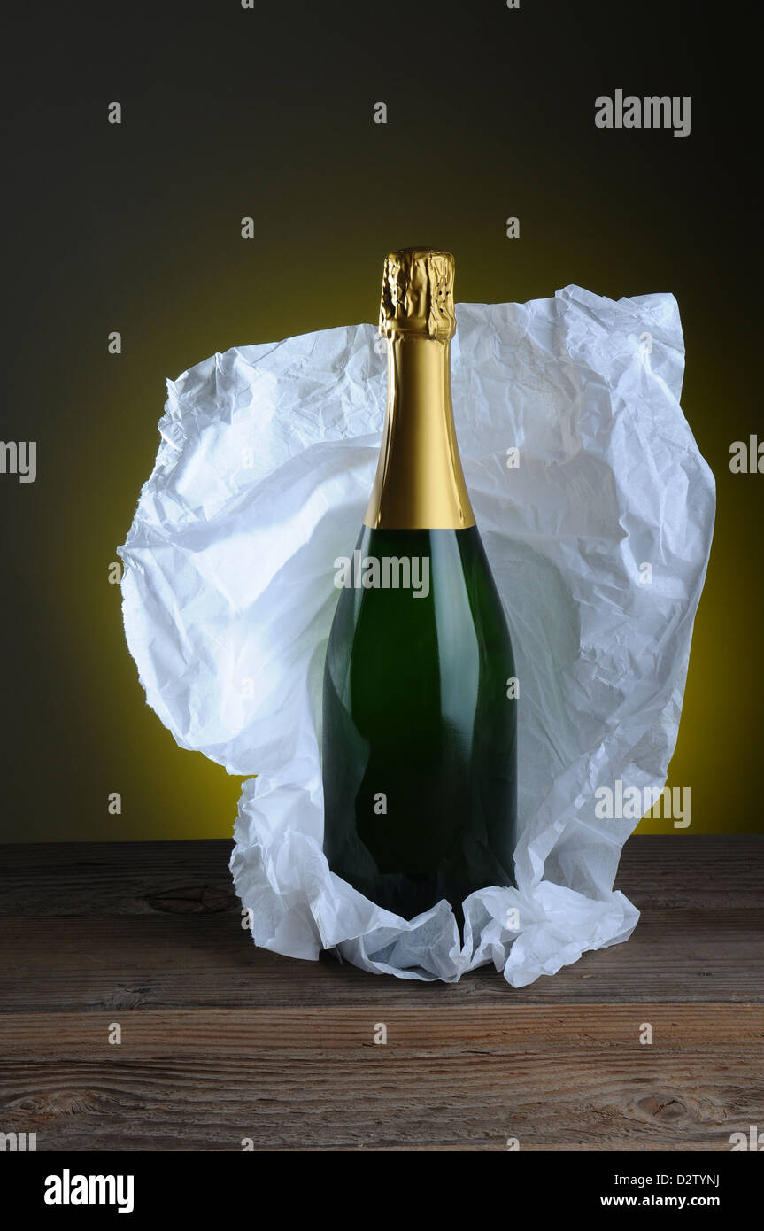 Bouteille de champagne de la vie toujours enveloppé dans du papier de soie  sur la surface du bois et de la lumière à fond sombre Photo Stock - Alamy