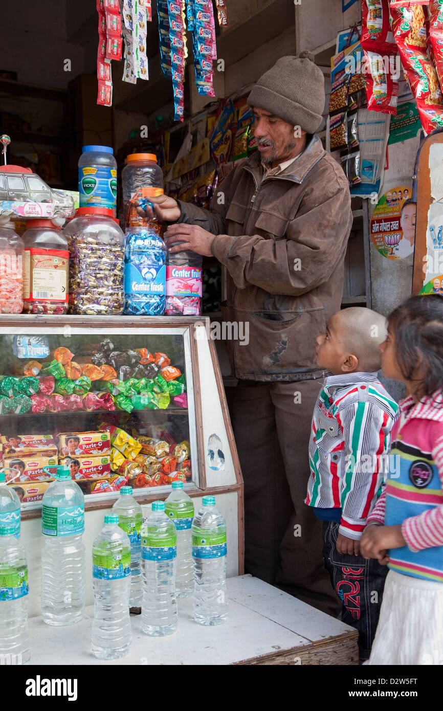 L'Inde, Rishikesh. Les enfants regarder Candy Shop de quartier en sélection. Banque D'Images