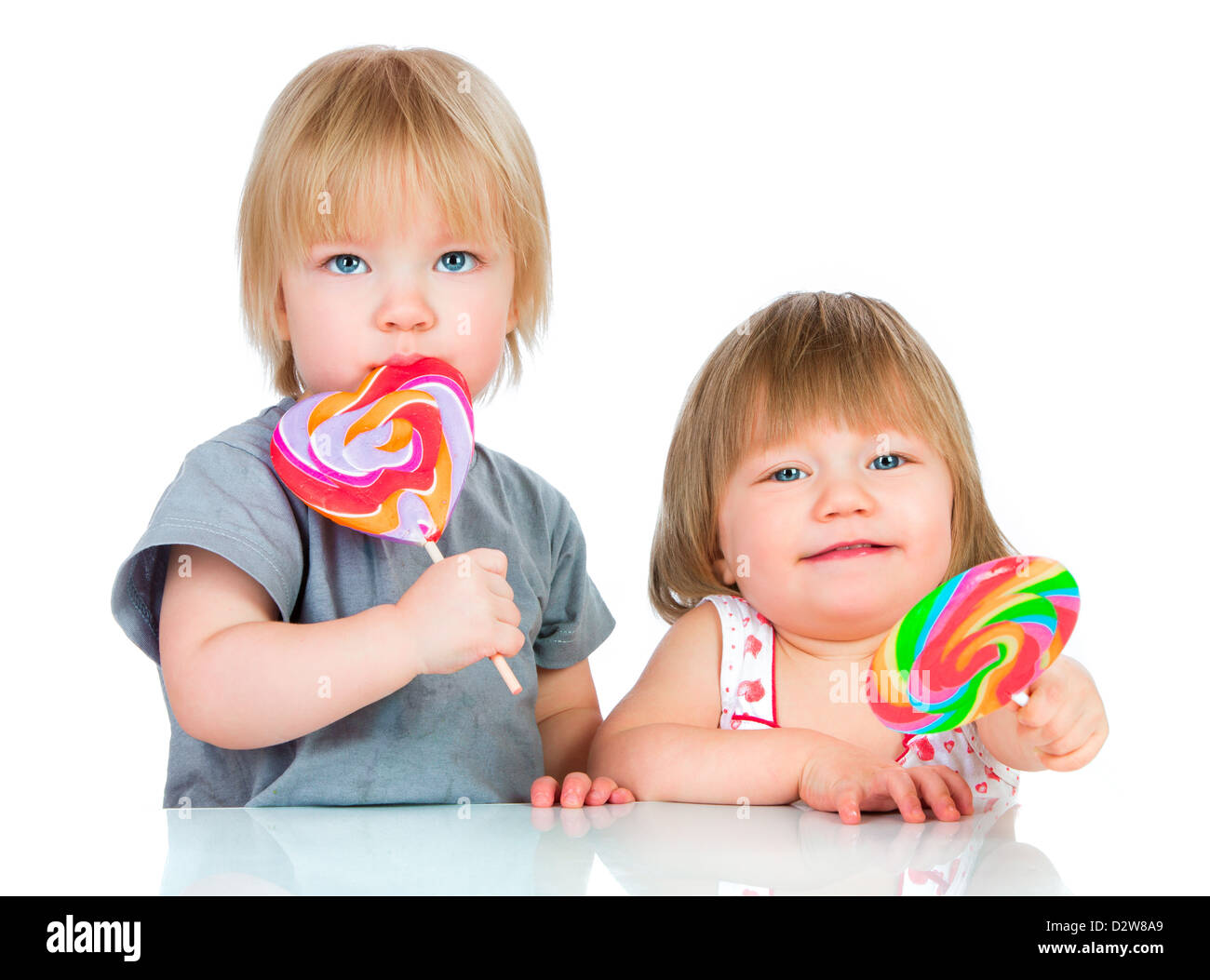 Les bébés manger une sucette collante sur fond blanc Banque D'Images