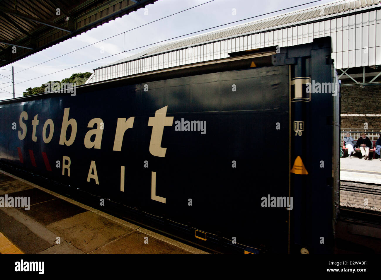 Services ferroviaires directes DRS Stobart Rail Pullman liveried rail container en passant par la gare de Oxenholme Banque D'Images
