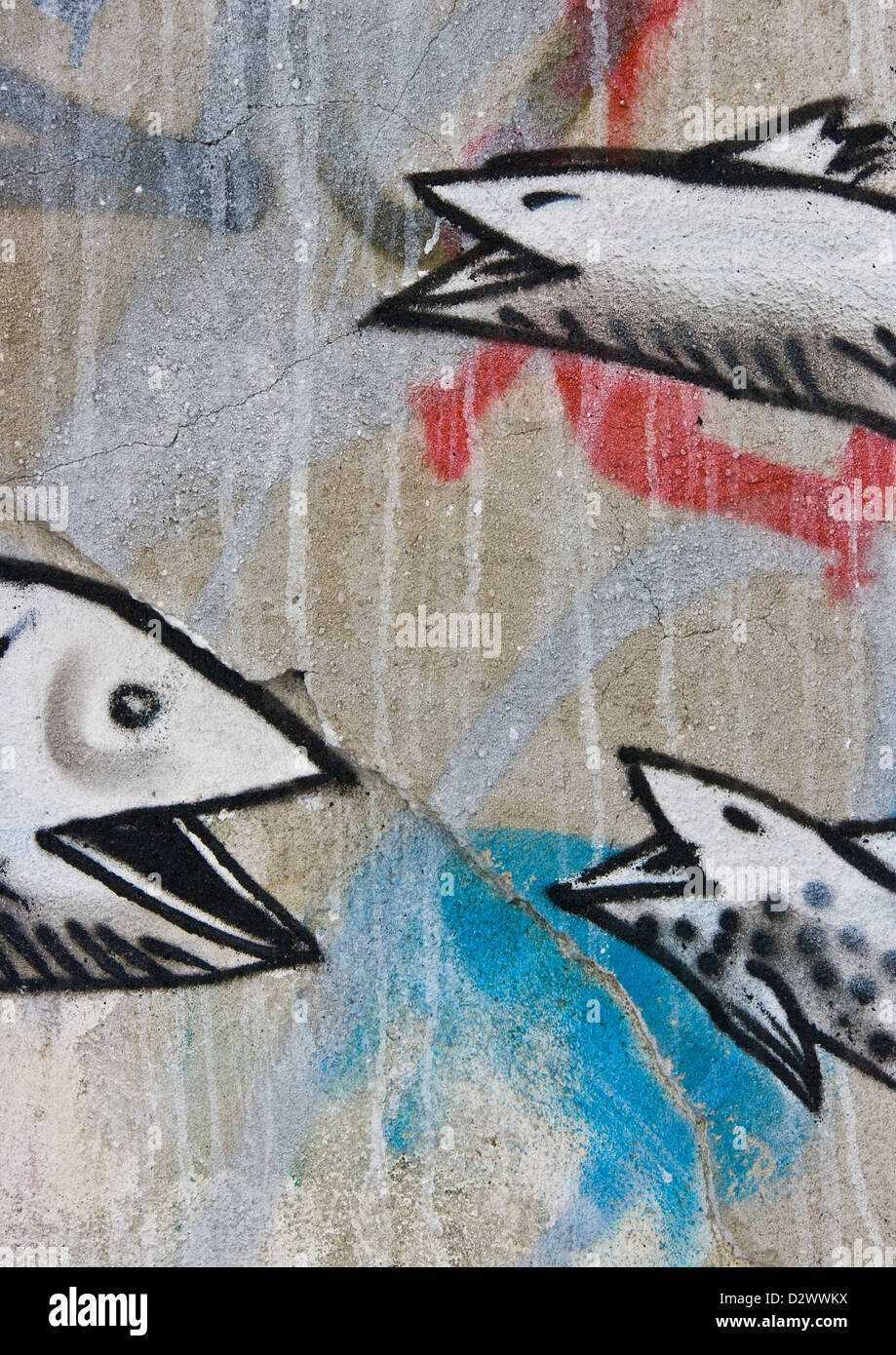 Street art graffiti urbain de trois poissons rire sur mur de béton fissurée texture est de Londres Angleterre Europe Banque D'Images