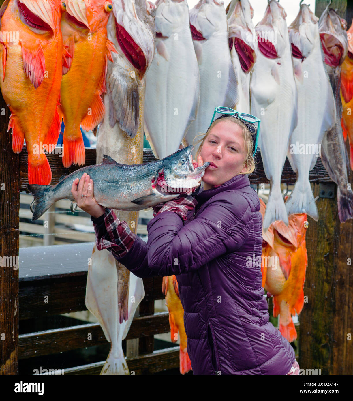 Charter boat fisher woman happily bisous poisson frais du jour pour l'appareil photo, Seward, Alaska, USA Banque D'Images