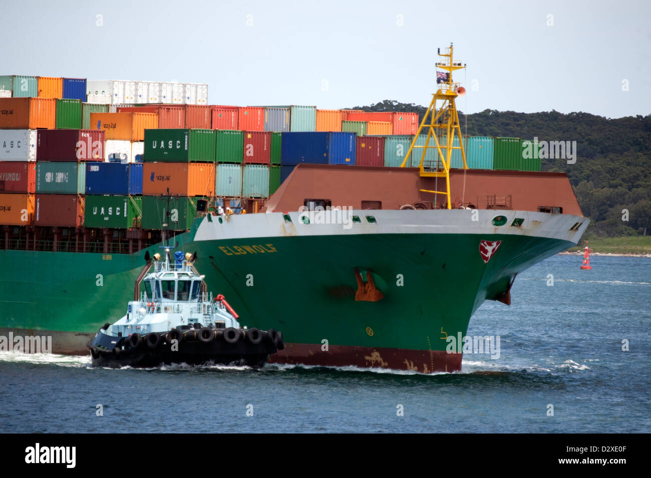 Elbwolf porte-conteneurs arrivant botanique de Port avec l'aide de remorqueur du port de Sydney, Australie Banque D'Images