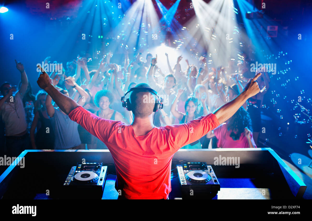 DJ avec bras tendus avec vue sur piste de danse Banque D'Images