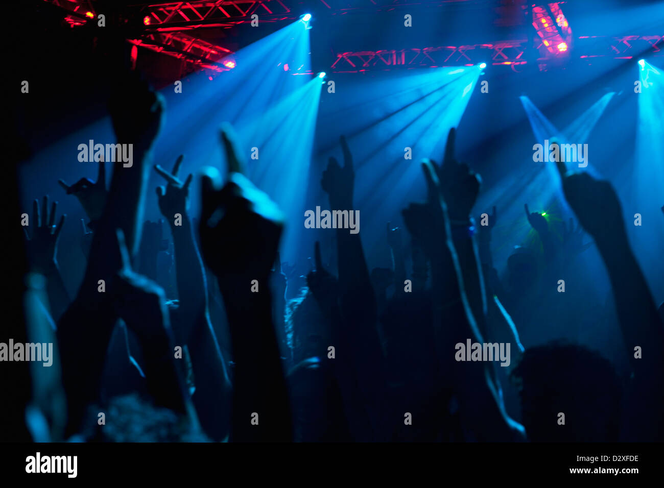Silhouette de foule acclamant avec bras levés au concert Banque D'Images