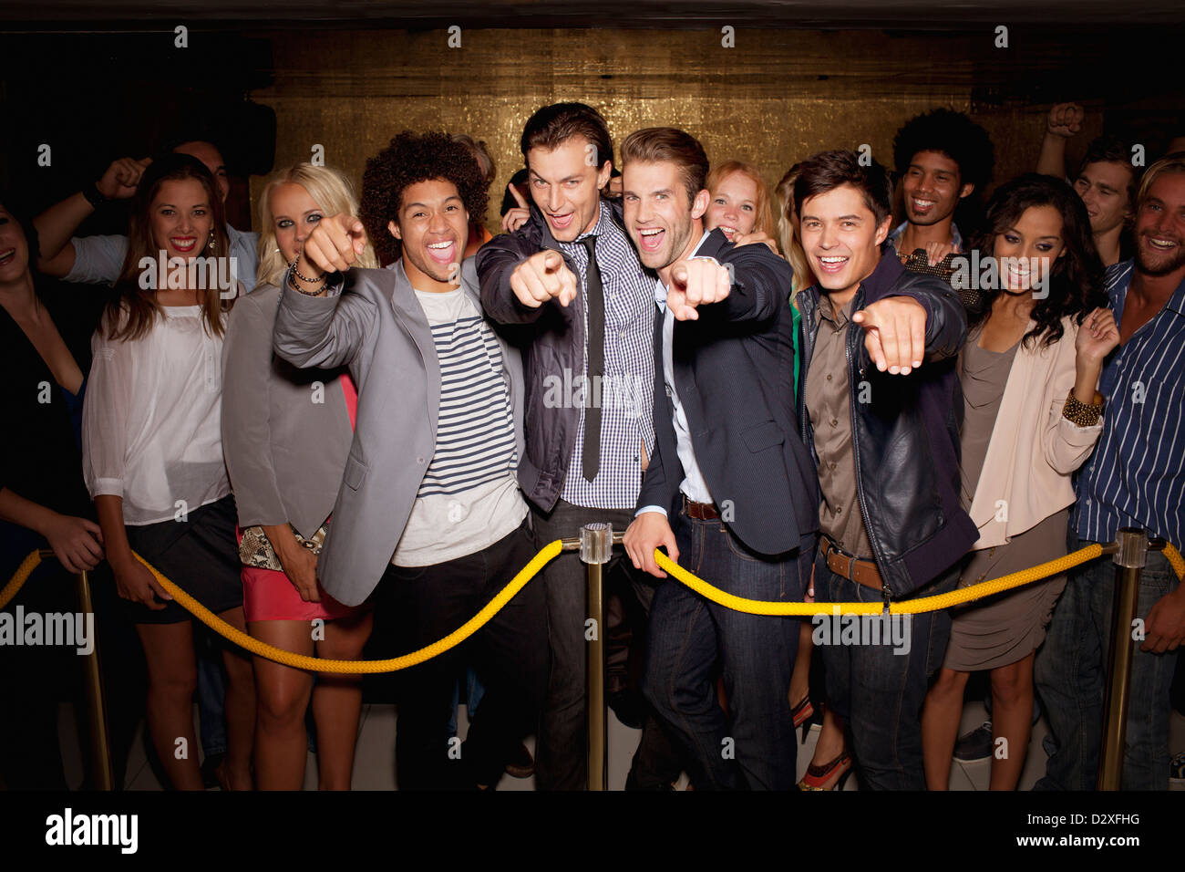 Portrait de foule enthousiaste en attente dans la file d'attente à l'extérieur de nuit Banque D'Images
