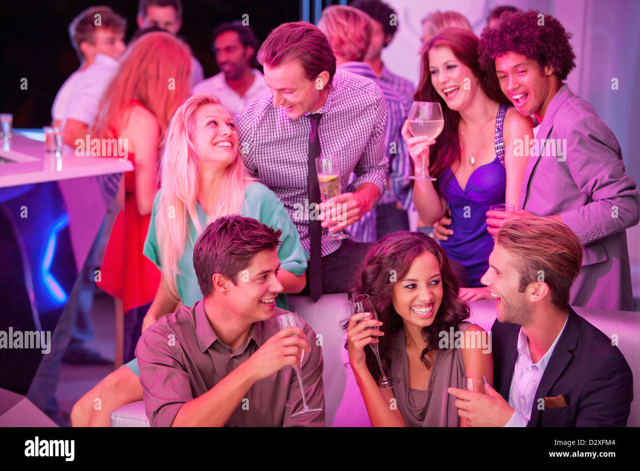Smiling friends drinking champagne in nightclub Banque D'Images