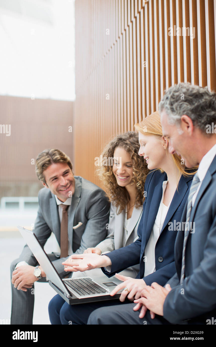 Smiling business people with laptop Banque D'Images