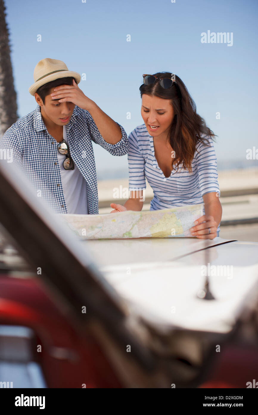 Frustrés couple reading road map Banque D'Images