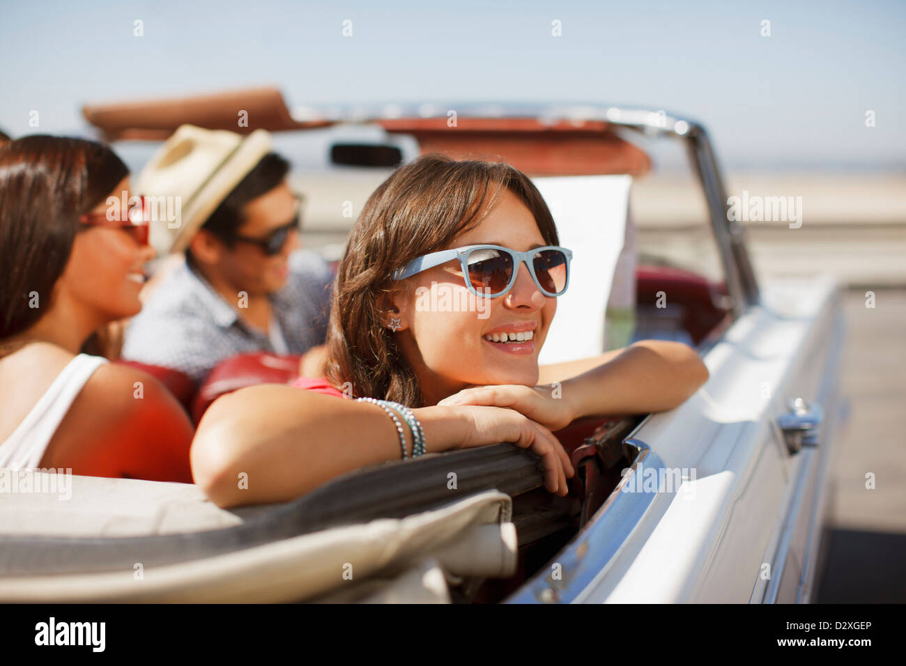 Smiling woman leaning out convertible Banque D'Images