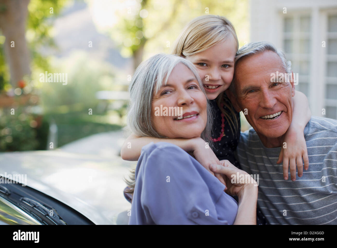 Vieux couple hugging granddaughter Banque D'Images