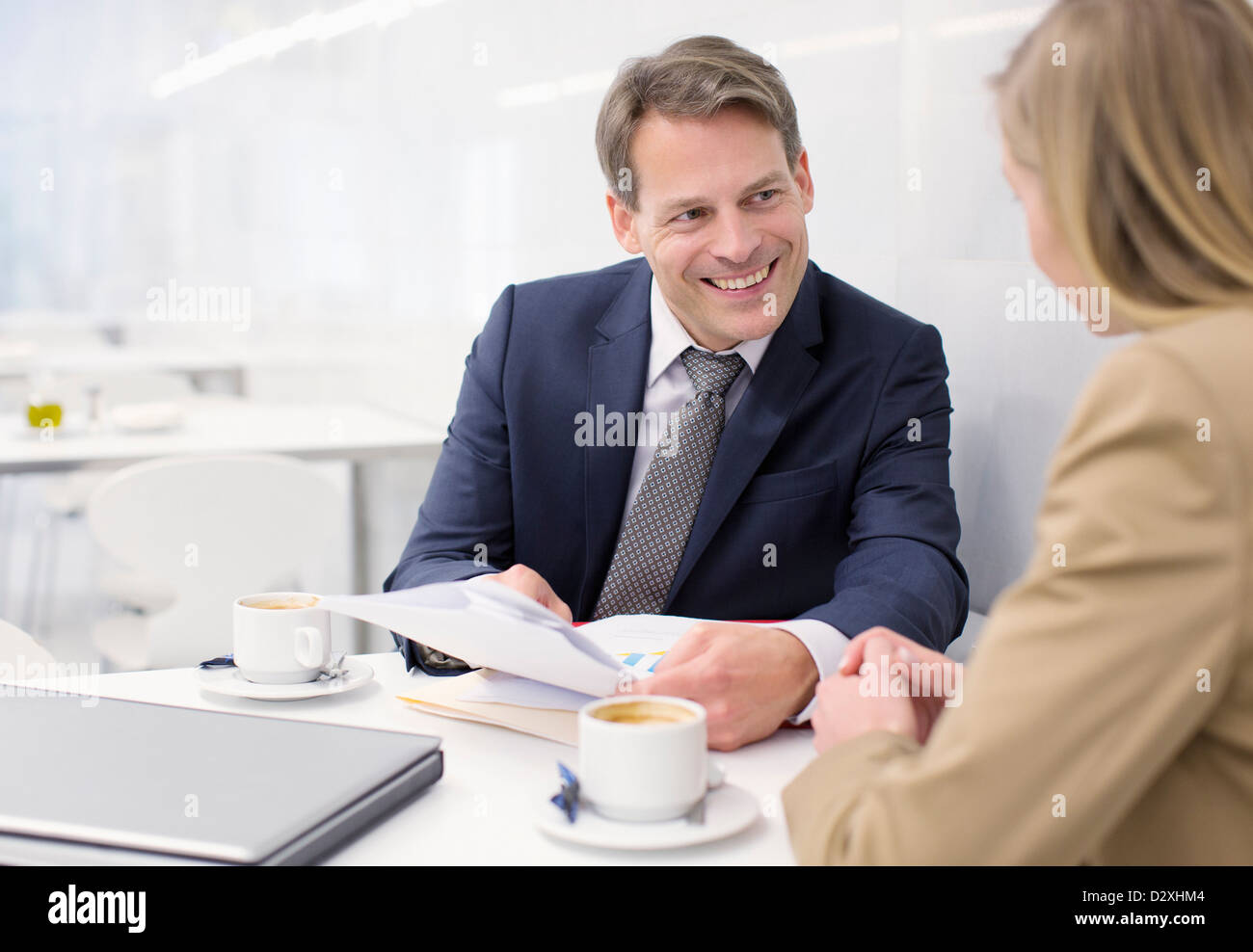 Smiling business people discussing paperwork in cafe Banque D'Images