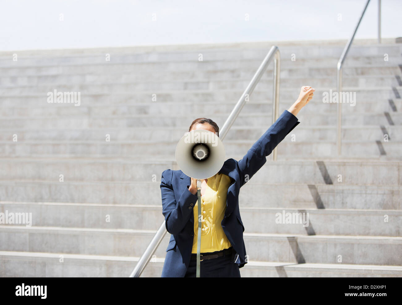 Businesswoman using megaphone sur mesures urbaines Banque D'Images