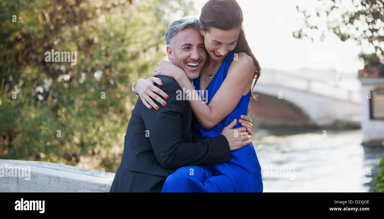 Bien habillé heureux couple hugging Banque D'Images