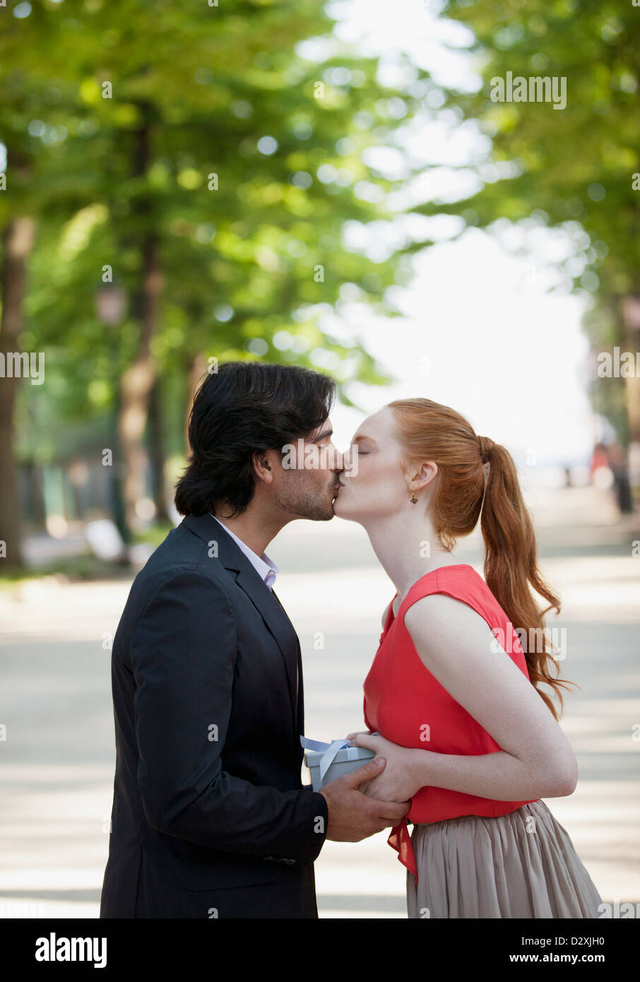 Couple kissing in park Banque D'Images