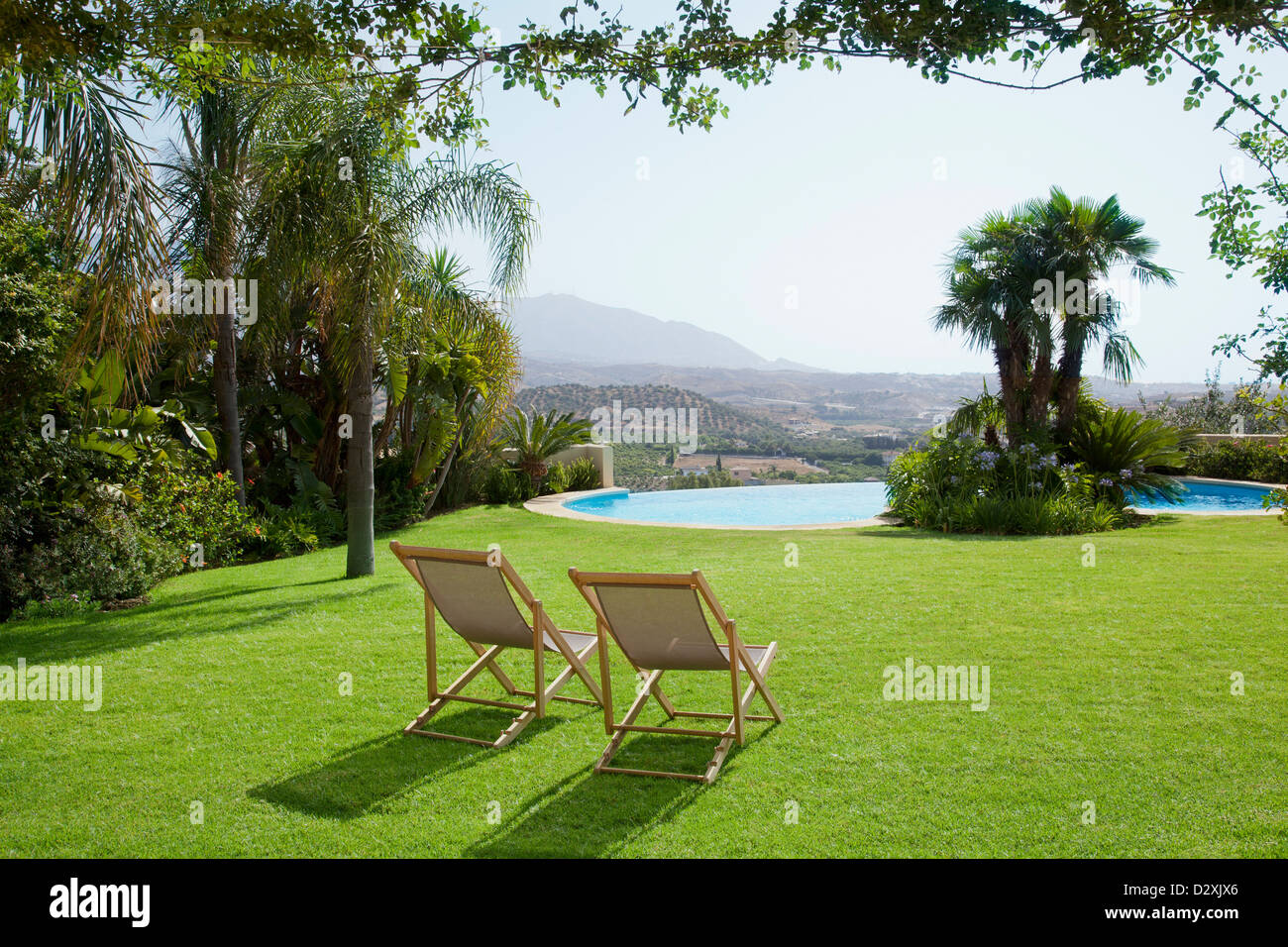 Chaise de jardin dans l'herbe avec vue sur piscine Banque D'Images