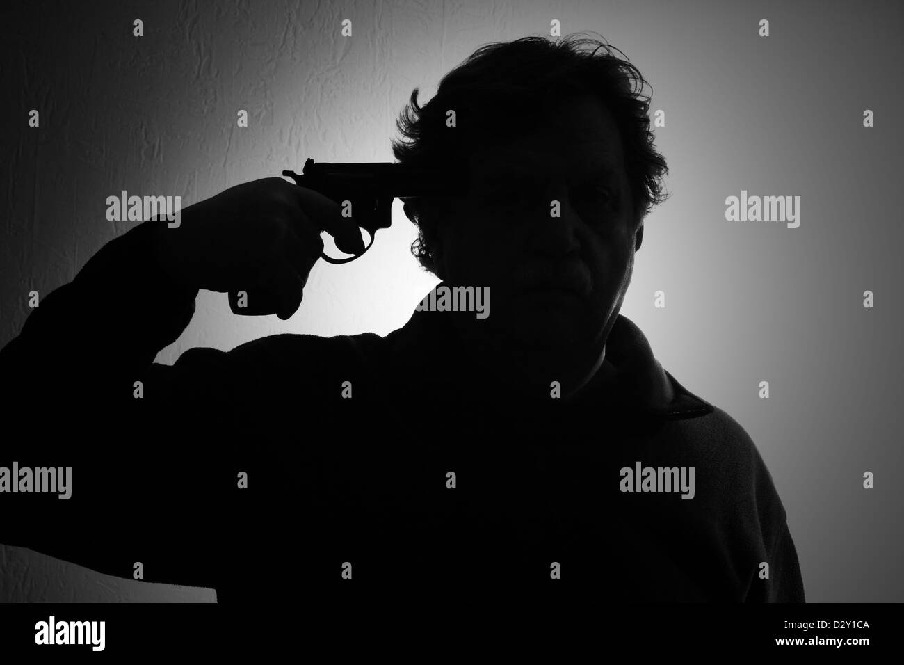 Le suicide, un homme un fusil vers sa tête, noir et blanc Banque D'Images