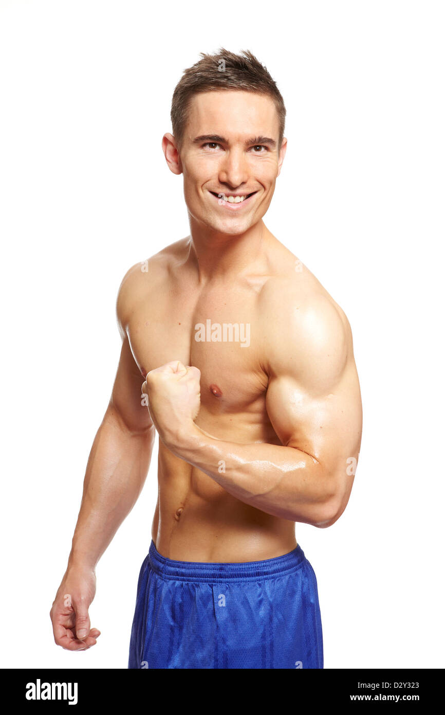 Muscular young man flexing muscles du bras en tenue de sport smiling on white background Banque D'Images