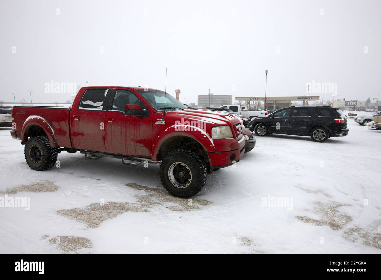 Camion et voitures garées dans le stationnement du magasin dans la tempête de blizzard Saskatoon Saskatchewan Canada Banque D'Images