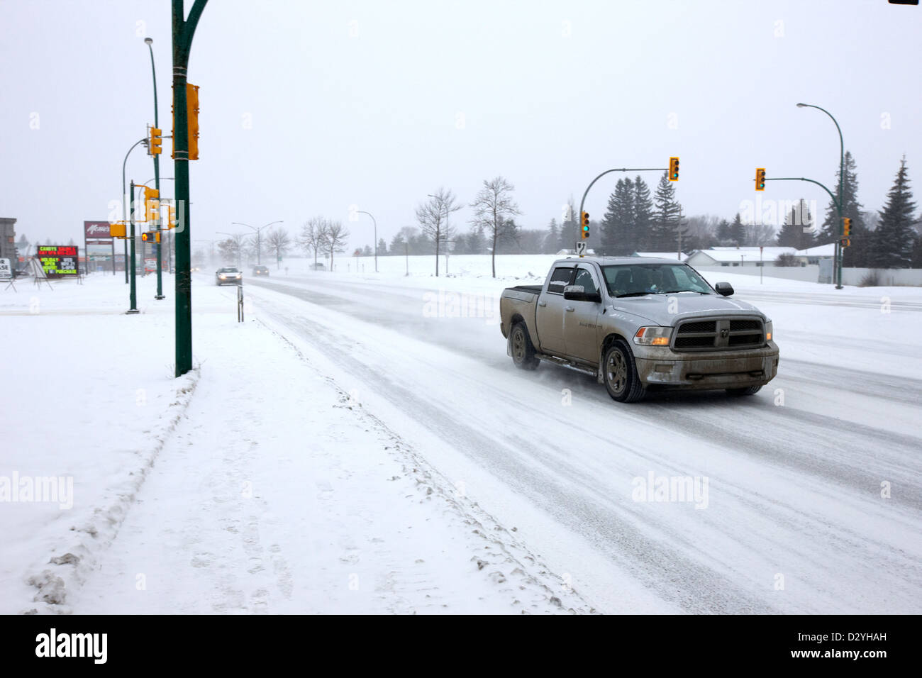 Voitures voyageant le long de la 8e rue dans le blizzard Saskatoon Saskatchewan Canada Banque D'Images